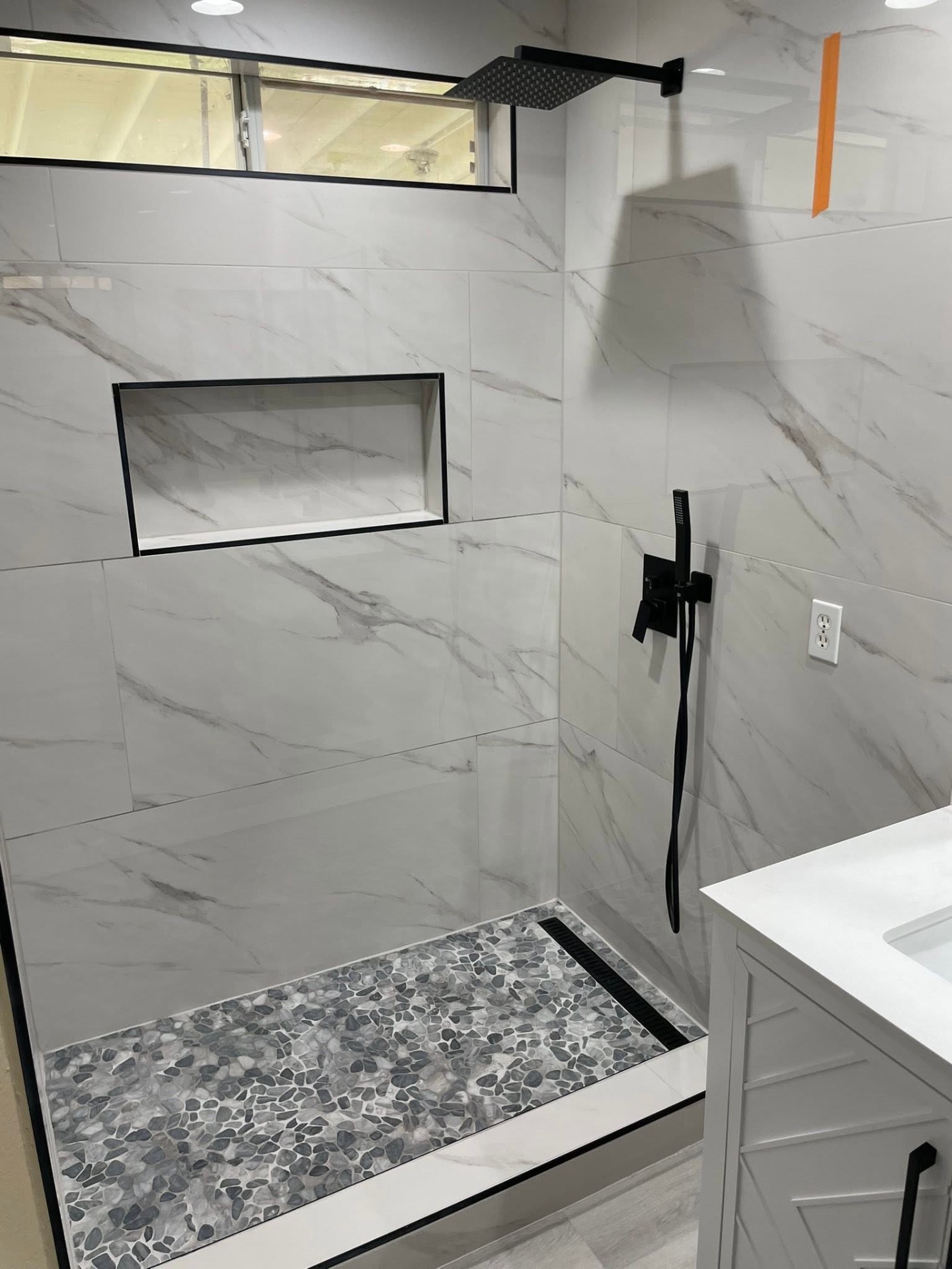 Marble tile shower, matte black finish.