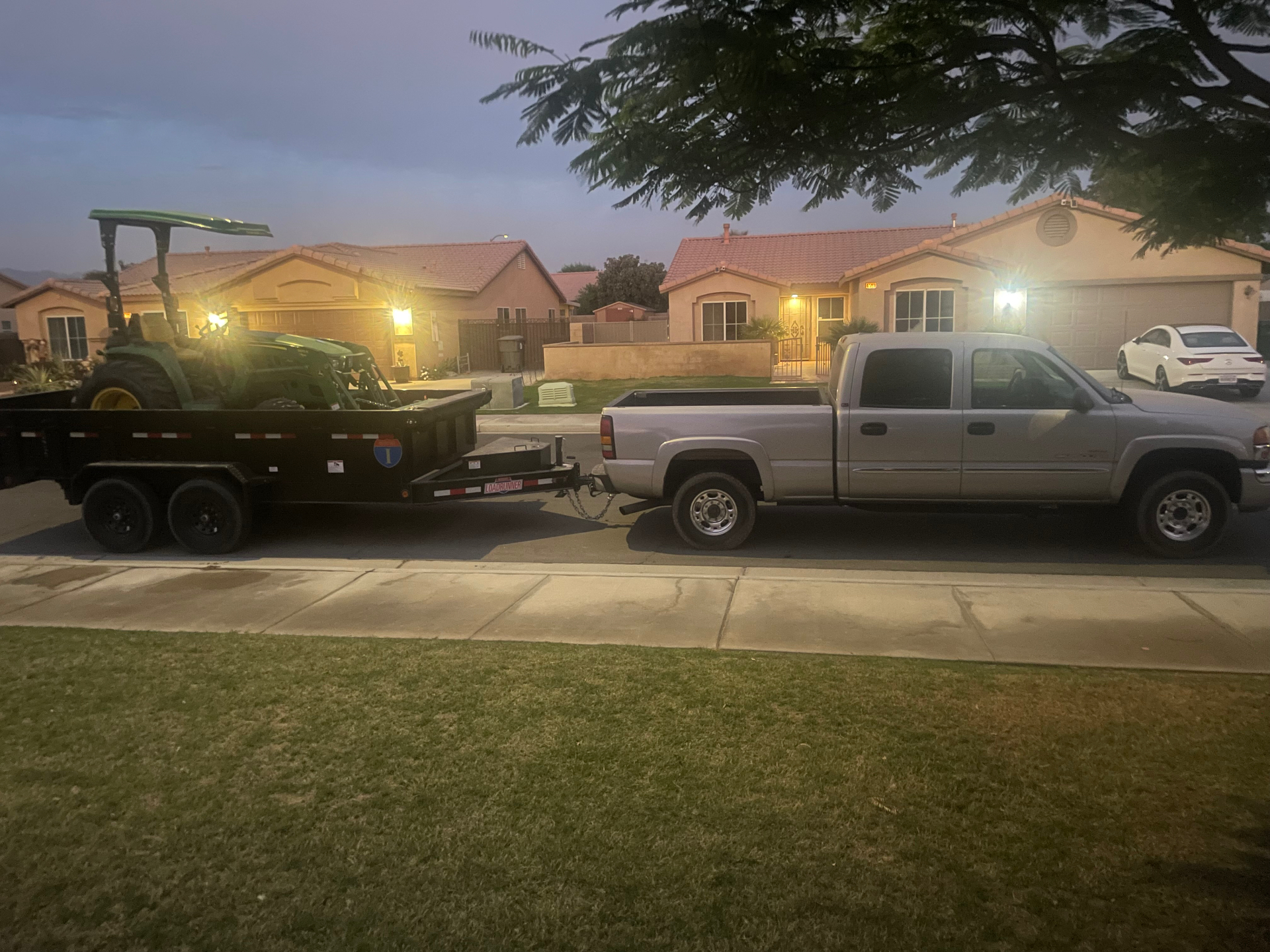 Rio's truck and trailer hauling equipment through a Coachella Valley neighborhood
